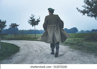 Rear View Of Vintage 1940s Military Officer Walking On Rural Road.