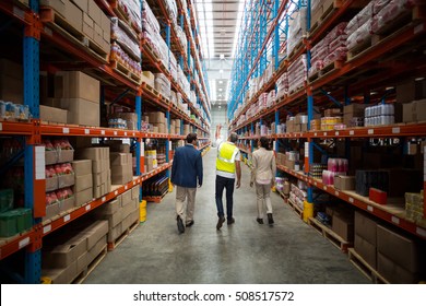 Rear view of warehouse team discussing while walking in warehouse