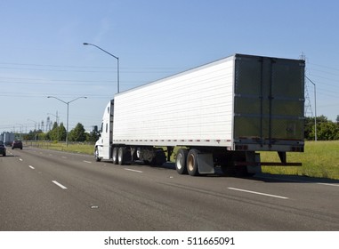 Rear View Of White Semi On Highway Under Blue Sky.