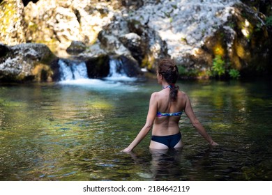 Rear View Of Wim Hof Method Cold Bathing For A Mid Adult Woman In A Cold Wild Water Stream