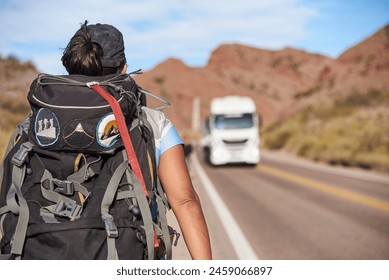 Rear view of a woman backpacker walking along the roadside, living an adventure during her vacations in Potrerillos, Mendoza, Argentina. Concepts: backpacking, healthy enjoyment of the outdoors. - Powered by Shutterstock