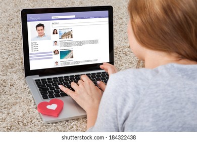 Rear View Of Woman Chatting On Social Networking Sites Using Laptop