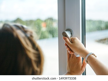 Rear view of woman closing opening modern pvc aluminum triple window