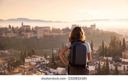 Rear view of woman enjoying sunset over Granada city landscape- Spain - Shutterstock ID 2320826185