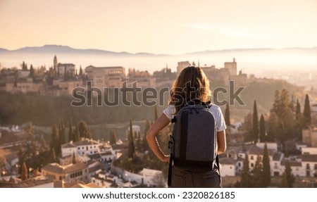 Rear view of woman enjoying sunset over Granada city landscape- Spain
