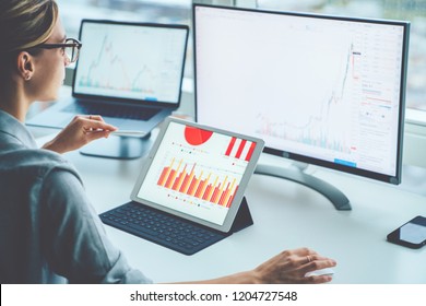 Rear view of woman financial specialist studying theory and practice blockchain technology. Female broker sitting front computer with graphs statistics of stock exchange. Earnings on raising quotes
