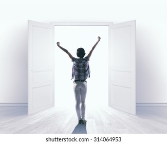 Rear View Of Woman With Hands Up Entering Opened Door