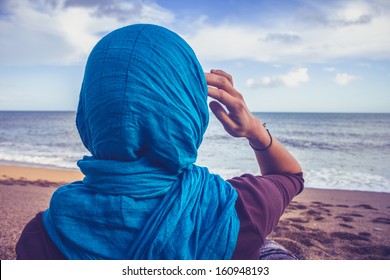 Rear view of woman with headscarf looking at the sea