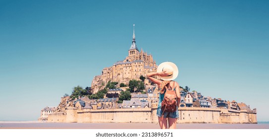Rear view of woman looking at Le Mont Saint Michel- Normandie in France