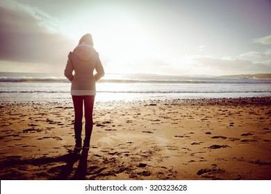 Rear View Of Woman Looking At The Sea During The Sunset On The Beach In Front Of Camera