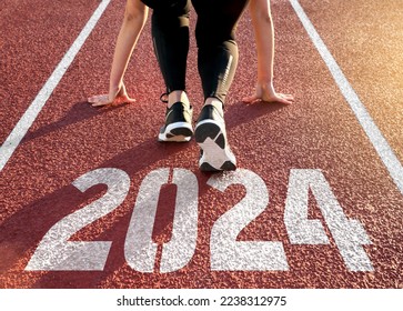 Rear view of a woman preparing to start on an athletics track engraved with the year 2024 - Powered by Shutterstock