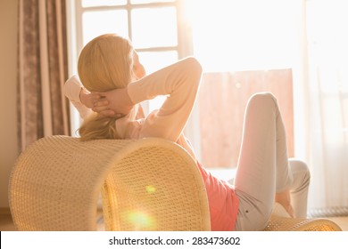 Rear View Of Woman Relaxing On Chair At Home