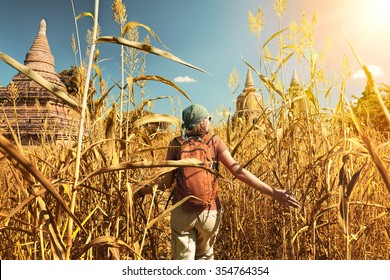 Rear View Of Woman Traveler With A Backpack Walking Through The Field To The Ancient Buddhist Stupas. Myanmar.
Concept Of Travel And Adventure In Asia.