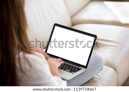 Rear view at woman writing on white laptop screen online working from home, female applicant typing cover letter applying for job, lady mailing customer support to give feedback or sending request