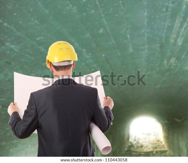 Rear view\
worker in a tunnel  light at end of\
tunnel