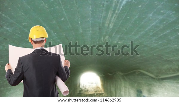 Rear view\
worker in a tunnel light at end of\
tunnel