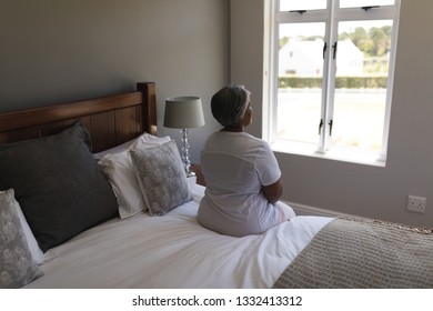 Rear view of worried senior African American woman relaxing in bedroom at home - Powered by Shutterstock