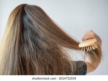 Rear View Of Young Asian Woman Brushing Her Thick Hair. Thick Hair Technically Refers To The Width Of A Single Strand Of Hair, Whereas Hair Density Refers To The Number Of Strands On Your Head.