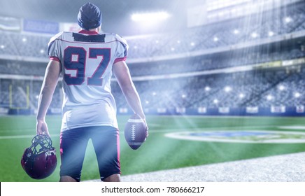 rear view of young confident American football player on the field of big modern stadium with lights and flares at night - Powered by Shutterstock