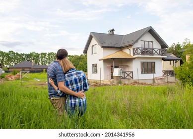 Rear View Of Young Couple Looking At Their New House