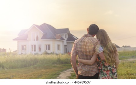 rear view of young couple looking at their new house