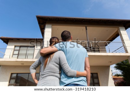 rear view of young couple looking at their new house