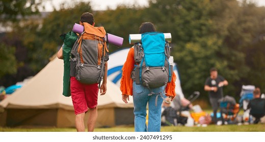 Rear View Of Young Couple Meeting At Summer Music Festival With Camping Equipment - Powered by Shutterstock