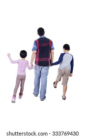 Rear View Of A Young Father And His Children Holding Hands In The Studio And Walking Together