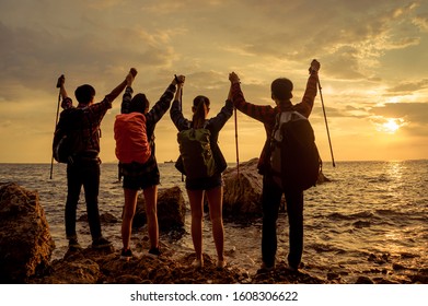 Rear View Of Young Friends Standing On The Stones On Background Of The Sea, 
Peoples Silhouettes,  Team Or Friendship Concept