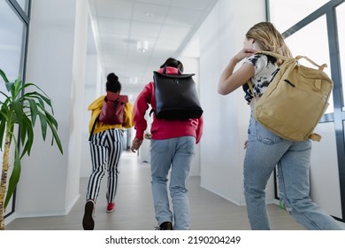Rear view of young high school students walking in corridor at school, back to school concept. - Powered by Shutterstock