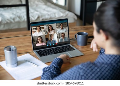 Rear view young indian ethnicity employee holding video conference web cam online meeting with happy mixed race colleagues, discussing working issues distantly at home office using computer app. - Shutterstock ID 1854698011