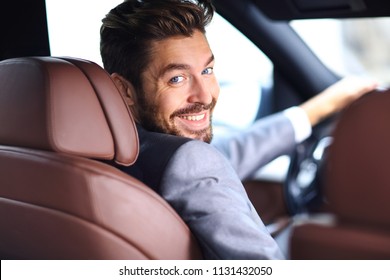 Rear View, Young Man Driving His Car, Looking At Camera