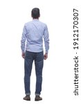 rear view . a young man in jeans looking at a white screen.