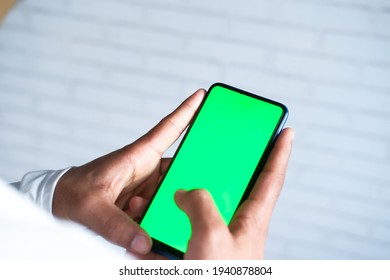 rear view of young man using smart phone indoor 