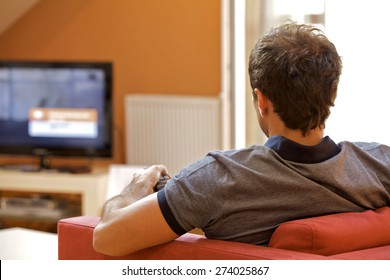 Rear View Of Young Man Watching Television