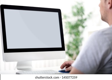 Rear view of a young man working of a computer - Powered by Shutterstock