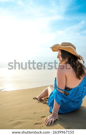Rear view of young model observing horizon with hat on beach at Patong beach