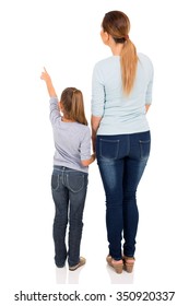 rear view of young mother and daughter pointing at empty space