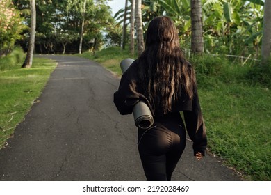 Rear View Of A Young Woman Carrying Yoga Mat