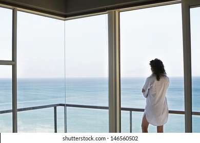 Rear View Of Young Woman Looking At Ocean View From Balcony At Resort