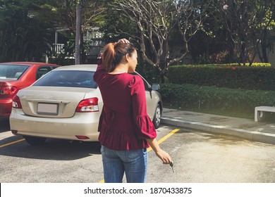 Rear view young woman stood with keys looking for her car in the parking lot, but couldn't find it : Woman was dazed because her car had been lost through the stolen