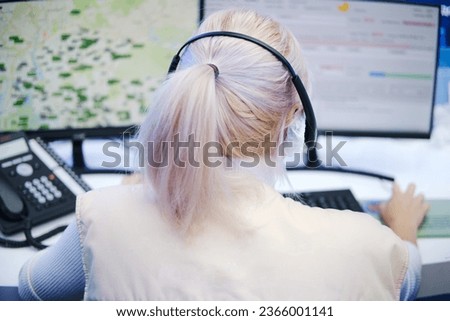 Rear view of a young woman working in a call center.