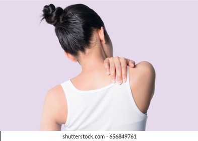 rear view of a young women holding her neck in pain. isolated on violet background.