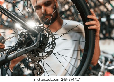 Rear wheel adjustment. Repair man in bicycle shop, working in store. - Powered by Shutterstock