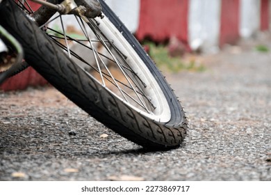 The rear wheel of the bicycle is flat and is left parked on the sidewalk to change and fix it. - Powered by Shutterstock