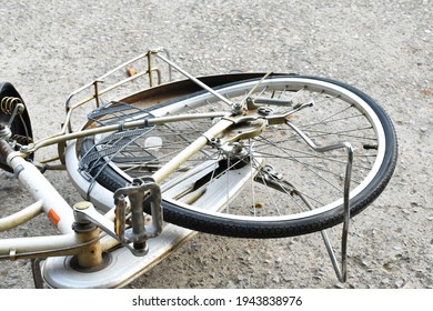 The rear wheel of the bicycle which fell down on cement floor by the road is bent and deformed because it has got accident and has been used for a long time.  - Powered by Shutterstock