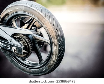 rear wheel of a motorcycle on blurred background, close up of motorcycle rear wheel with chain and disc brake - Powered by Shutterstock