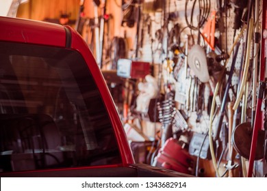 Rear Window And Cab Of Red Truck Next To Wall Of Mechanic's Tools In An Old Shop Or Garage