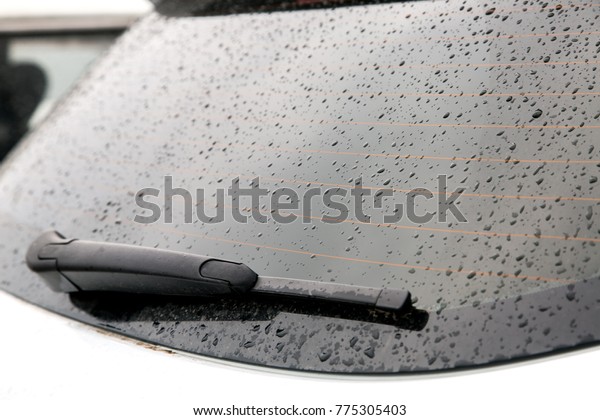 The rear\
window of the car is covered with water droplets after the rain,\
the heated rear window and the car\
wiper.