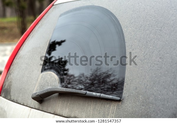 Rear window\
side view of a dirty car with a\
wiper.